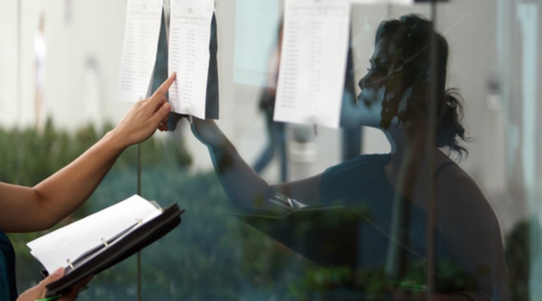 September 4, 2012--Lawrenceville--First time bidder, Bounneth Choummanivong (CQ) of Lawrenceville, looks at a list of foreclosed properties that are up for bidding at the front entrance of Gwinnett Justice and Administration Center Tuesday. VINO WONG / VWONG@AJC.COM