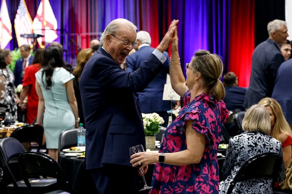 Alabama Sen. Jabo Waggoner, left, high fives a guest as they wait for Donald Trump Jr. to speak at the Alabama Republican Party's Trump Victory Celebration, Thursday, April 3, 2025, in Birmingham, Ala. (AP Photo/Butch Dill)