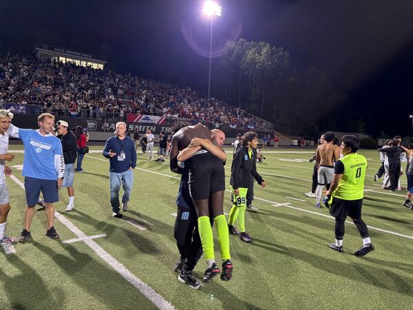 Meadowcreek keeper Alexandre Diouf gets a big hug after the Mustangs won the Class 6A soccer championship, beating Walton 4-3 on penalty kicks, on Thursday, May 14, 2026, at Duluth High School. (Stan Awtrey for the AJC)