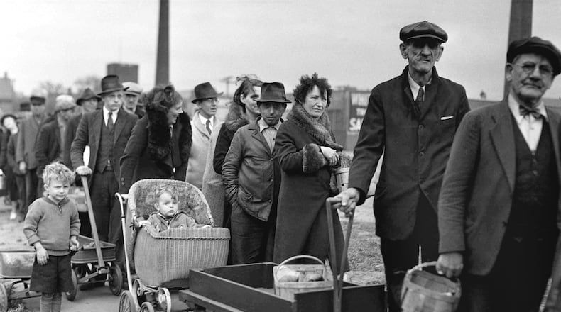 The flood of layoffs caused by the coronavirus shutdowns has sent more Americans into unemployment than at any time since the Great Depression. Here, in a photo from May 9, 1938, people stand in line for their portions of a federal surplus of potatoes and cabbages. (AP Photo, file)