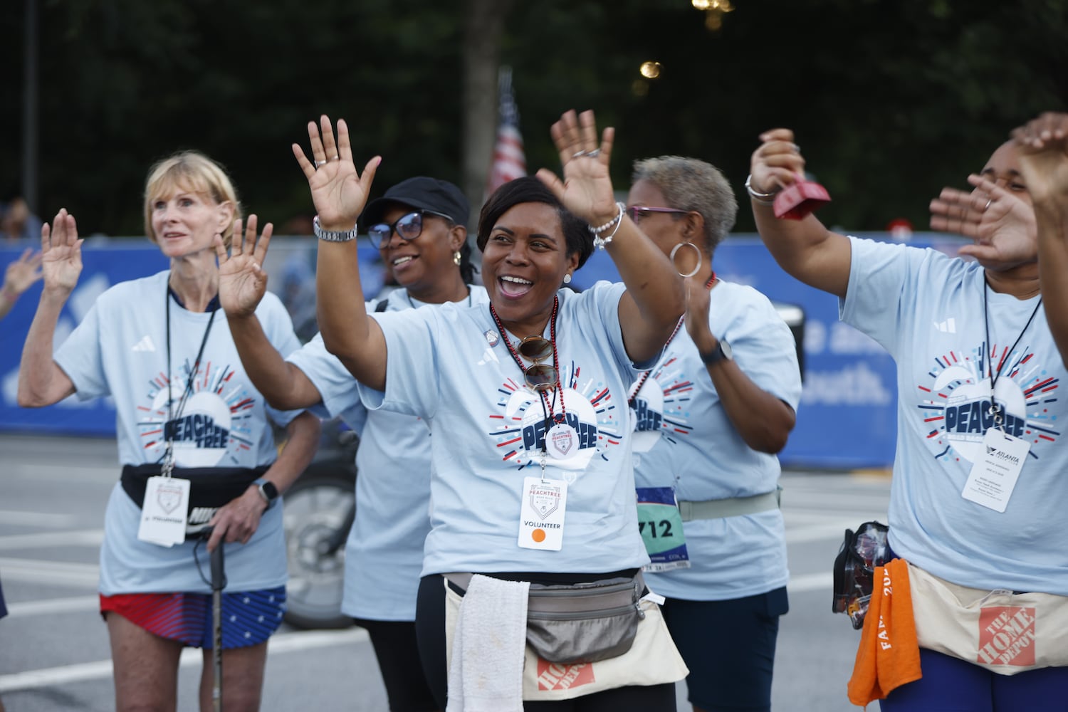 Volunteers cheer at the start of the 56th running of the Atlanta Journal-Constitution Peachtree Road Race on Friday, July 4, 2025, in Atlanta. (Arvin Temkar/AJC)