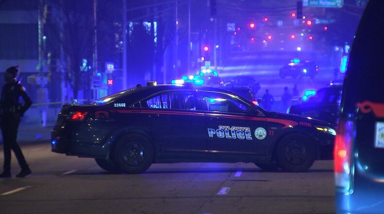 The officer fired shots while trying to break up a gunfight, officials said.