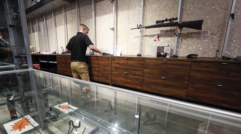 An employee cleans counters at a nearly empty display at Stoddard’s Range and Guns, in Atlanta, where the store has seen an uptick in ammunition and gun sales as the coronavirus threat intensifies. Bob Andres / robert.andres@ajc.com