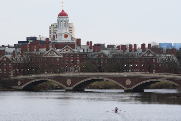 A sculler rows down the Charles River near Harvard University, at rear, Tuesday, April 15, 2025, in Cambridge, Mass. (AP Photo/Charles Krupa)