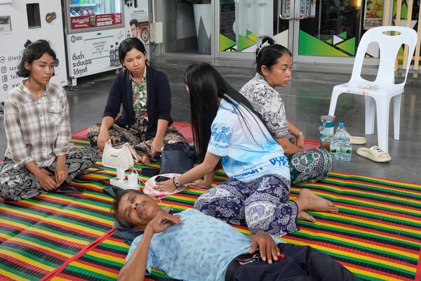 Naruemol Thonglek, top right, waits for news of her partner, sitting with other people looking for their relatives who were at the site where an under-construction high-rise building collapsed after an earthquake in Bangkok, Thailand, Monday, March, 31, 2025. (AP Photo/Manish Swarup)