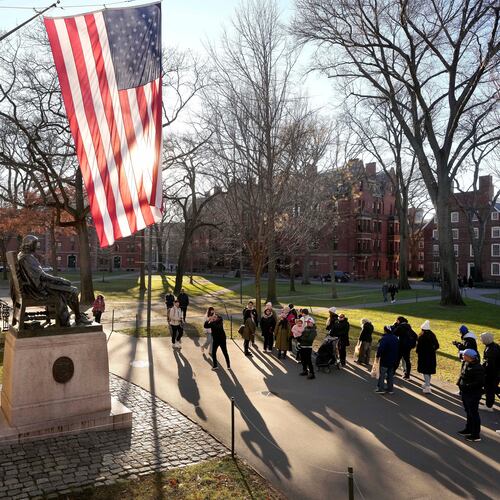 FILE - People take photos near a John Harvard statue, left, on the Harvard University campus, Jan. 2, 2024, in Cambridge, Mass. r. (AP Photo/Steven Senne, File)