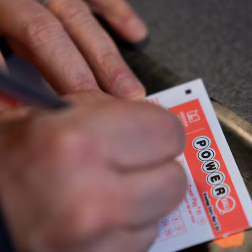 A person fills out a Powerball lottery ticket on Monday, Dec. 22, 2025, in Portland, Ore. (AP Photo/Jenny Kane)