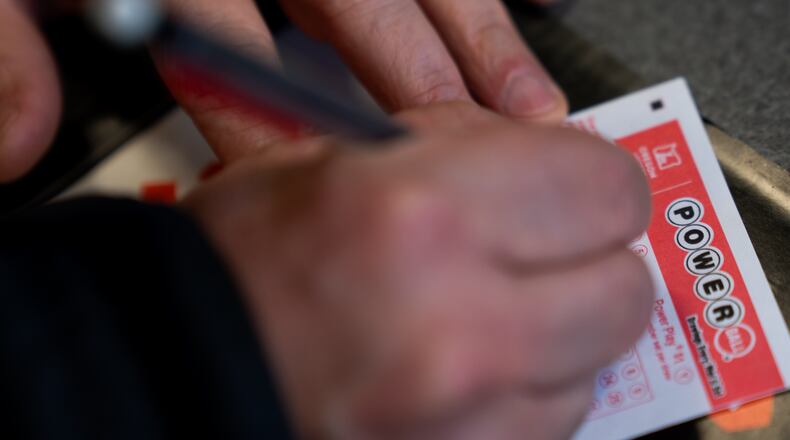 A person fills out a Powerball lottery ticket on Monday, Dec. 22, 2025, in Portland, Ore. (AP Photo/Jenny Kane)
