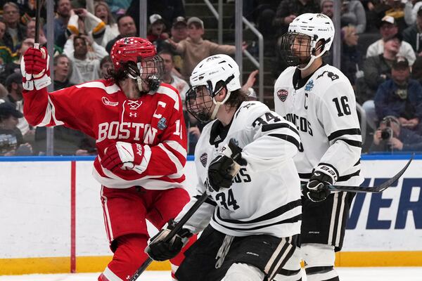 Boston University's Shane Lachance, left, celebrates after scoring as Western Michigan's Owen Michaels (34) and Tim Washe (16) stand by during the second period in the championship game of the NCAA Frozen Four men's college hockey tournament, Saturday, April 12, 2025, in St. Louis (AP Photo/Jeff Roberson)