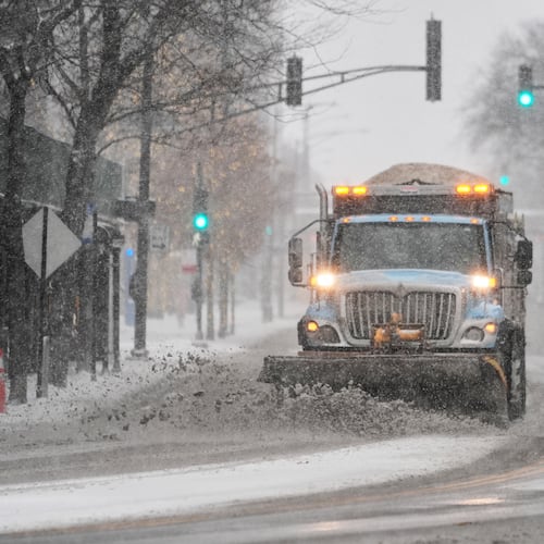 A plow clears snow from the road Saturday, Nov. 29, 2025, in Chicago. (AP Photo/Kiichiro Sato)