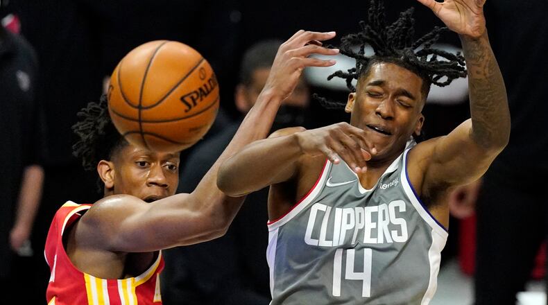 Hawks forward De'Andre Hunter and Los Angeles Clippers guard Terance Mann go after a rebound during the first half Monday, March 22, 2021, in Los Angeles. (AP)