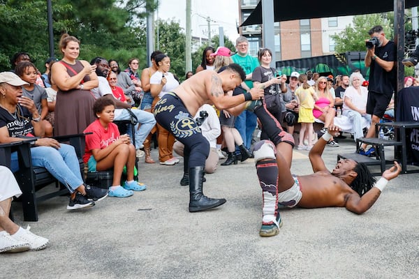 Apollo Prince, left, fights with DJ Smoke outside the ring while the crowd watches during a wrestling match at New Realm Brewing on Sunday, August 31, 2025, in Atlanta. Deep South Wrestling has been hosting free events since 2022, fully embracing what we call "unabashed entertainment." (Miguel Martinez/AJC)