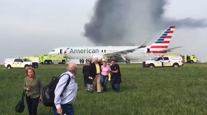 In this photo provided by passenger Jose Castillo, fellow passengers walk away from a burning American Airlines jet that aborted takeoff and caught fire on the runway at Chicago's O'Hare International Airport on Friday, Oct. 28, 2016. Pilots on Flight 383 bound for Miami reported an engine-related mechanical issue, according to an airline spokeswoman. (Jose Castillo via AP)