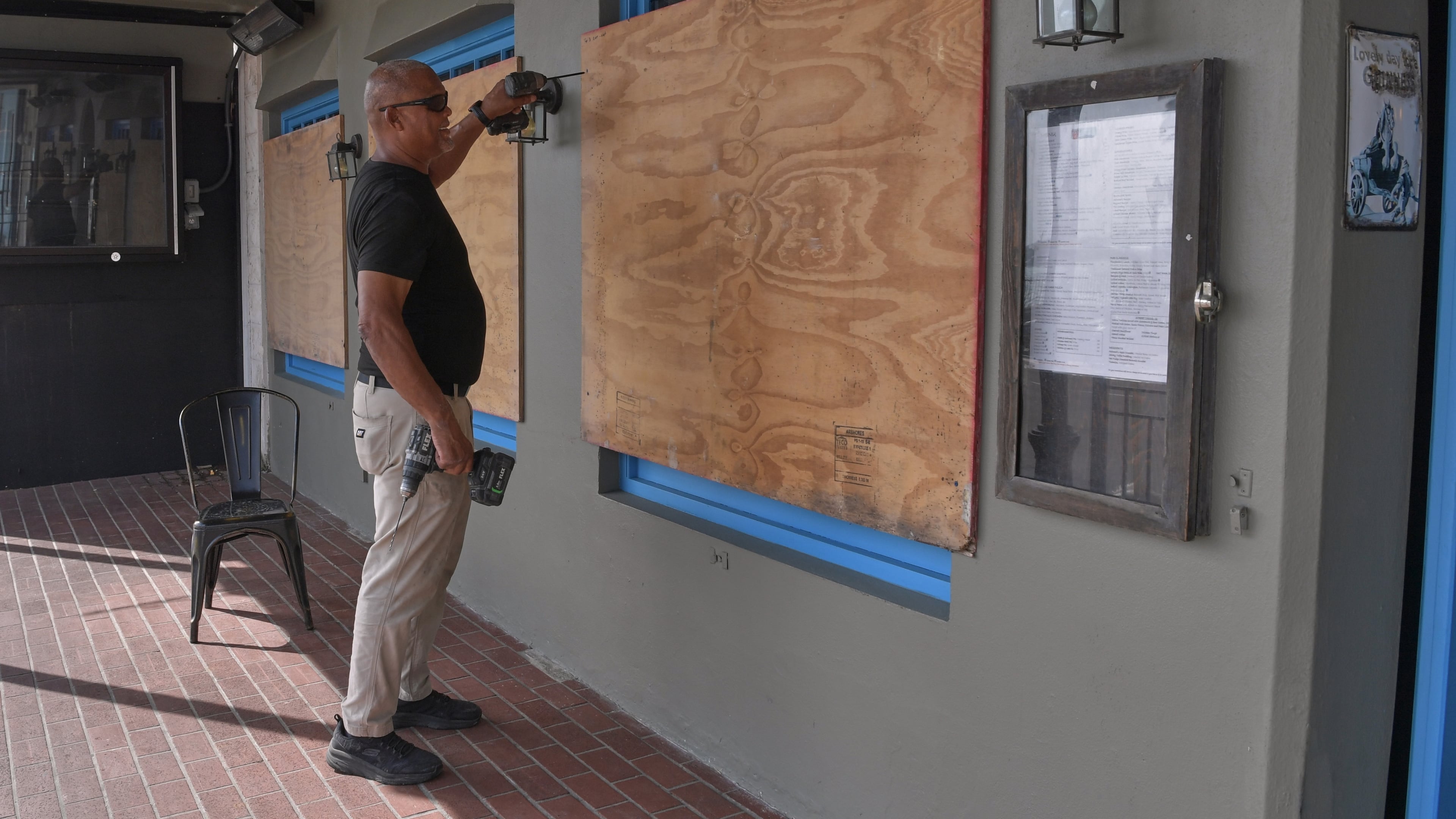 A man boards up his business' windows in preparation of Hurricane Imelda in Hamilton, Bermuda, Wednesday, Oct. 1, 2025. (AP Photo/Anthony Wade)