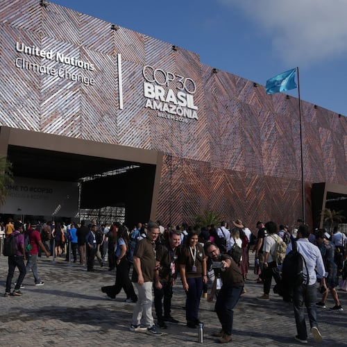 People pose for photos outside the venue for the COP30 U.N. Climate Summit, Monday, Nov. 10, 2025, in Belem, Brazil. (AP Photo/Fernando Llano)