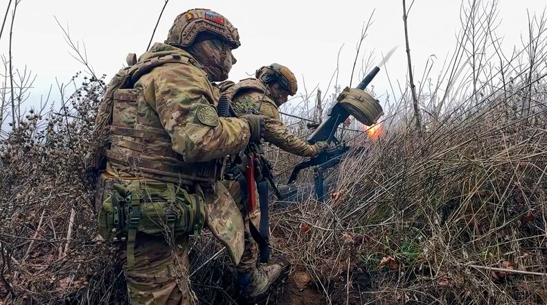 In this image made from video provided by Russian Defense Ministry Press Service on Tuesday, March 31, 2026, Russian soldiers fire a grenade launcher towards Ukrainian positions on an undisclosed location in Ukraine. (Russian Defense Ministry Press Service via AP)