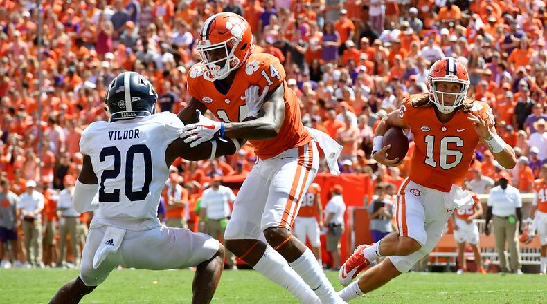 Quarterback Trevor Lawrence #16 runs the football as wide receiver Diondre Overton #14 of the Clemson Tigers blocks cornerback Kindle Vildor #20 of the Georgia Southern Eagles during the football game at Clemson Memorial Stadium on September 15, 2018 in Clemson, South Carolina. (Photo by Mike Comer/Getty Images)