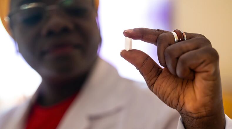 In this photo provided by the Drugs for Neglected Diseases initiative, Dr. Mariame Camara holds an acoziborole pill at the Dubreka Clinical Trial site, in Dubreka, Guinea, in 2024. (Brent Stirton/DNDi)