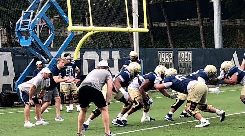 Georgia Tech offensive-line coach Brent Key (left, hands on knees) oversees a drill at a practice Aug. 8, 2022. (AJC photo by Ken Sugiura)