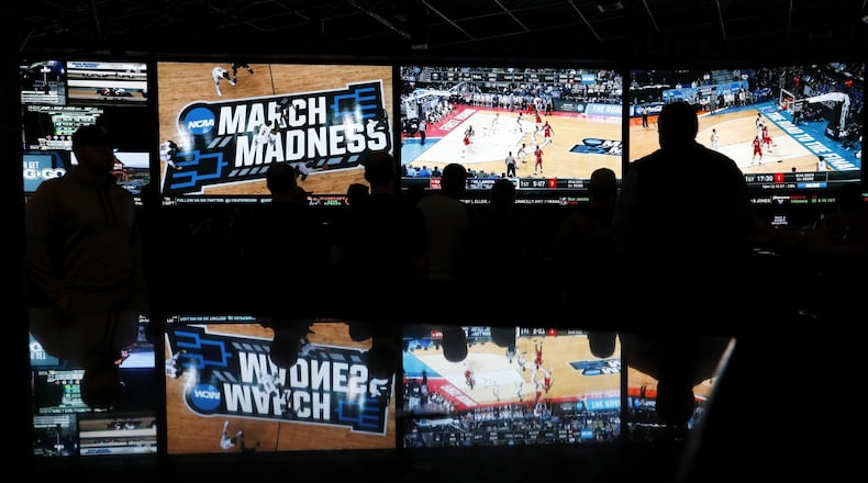People watch coverage of the first round of the NCAA college basketball tournament at the Westgate Superbook sports book in Las Vegas. The Supreme Court has struck down a federal law that bars gambling on baseball, basketball, football and other sports in most states, giving states the go-ahead to legalize betting on sports. (AP Photo/John Locher)