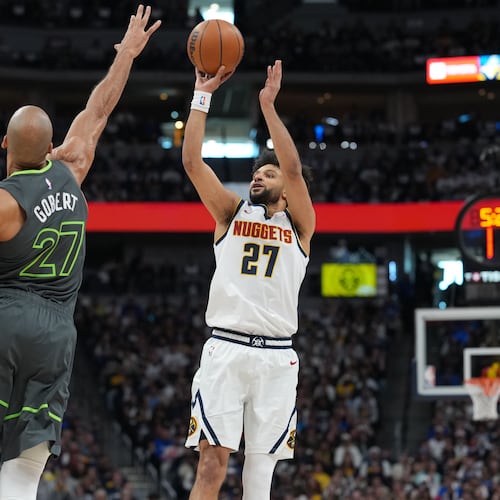 Denver Nuggets guard Jamal Murray, right, shoots over Minnesota Timberwolves center Rudy Gobert in the first half in Game 1 of a first-round NBA playoffs basketball series, Saturday, April 18, 2026, in Denver. (AP Photo/David Zalubowski)
