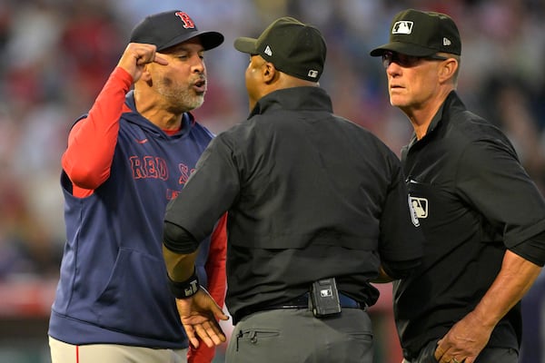 Boston Red Sox manager Alex Cora argues with umpire Alan Porter, center, as umpire Jim Wolf, right, looks on after he was ejected in the fifth inning during a baseball game against the Los Angeles Angels, Monday, June 23, 2025, in Anaheim, Calif. (AP Photo/Jayne Kamin-Oncea)