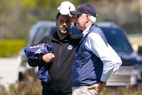 Atlanta Braves general manager, Alex Anthopoulos, left, speaks to Chairman and CEO Terry McGuirk at the CoolToday Park during spring training, Monday, March 14, 2022, in North Port, Fla. (AP Photo/Steve Helber)