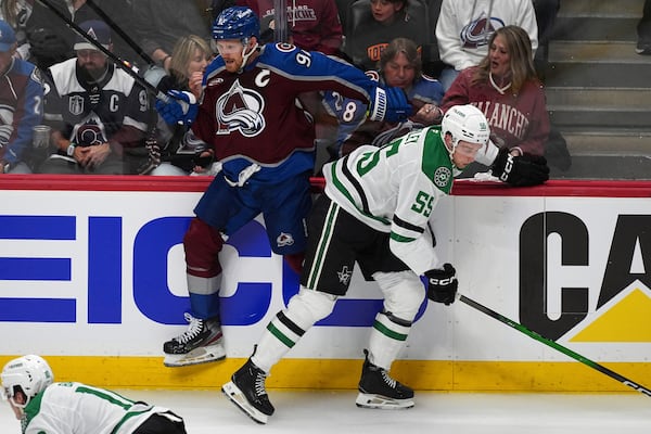 Dallas Stars defenseman Thomas Harley, right, checks Colorado Avalanche left wing Gabriel Landeskog in the first period of Game 3 of an NHL hockey first-round playoff series Wednesday, April 23, 2025, in Denver. (AP Photo/David Zalubowski)
