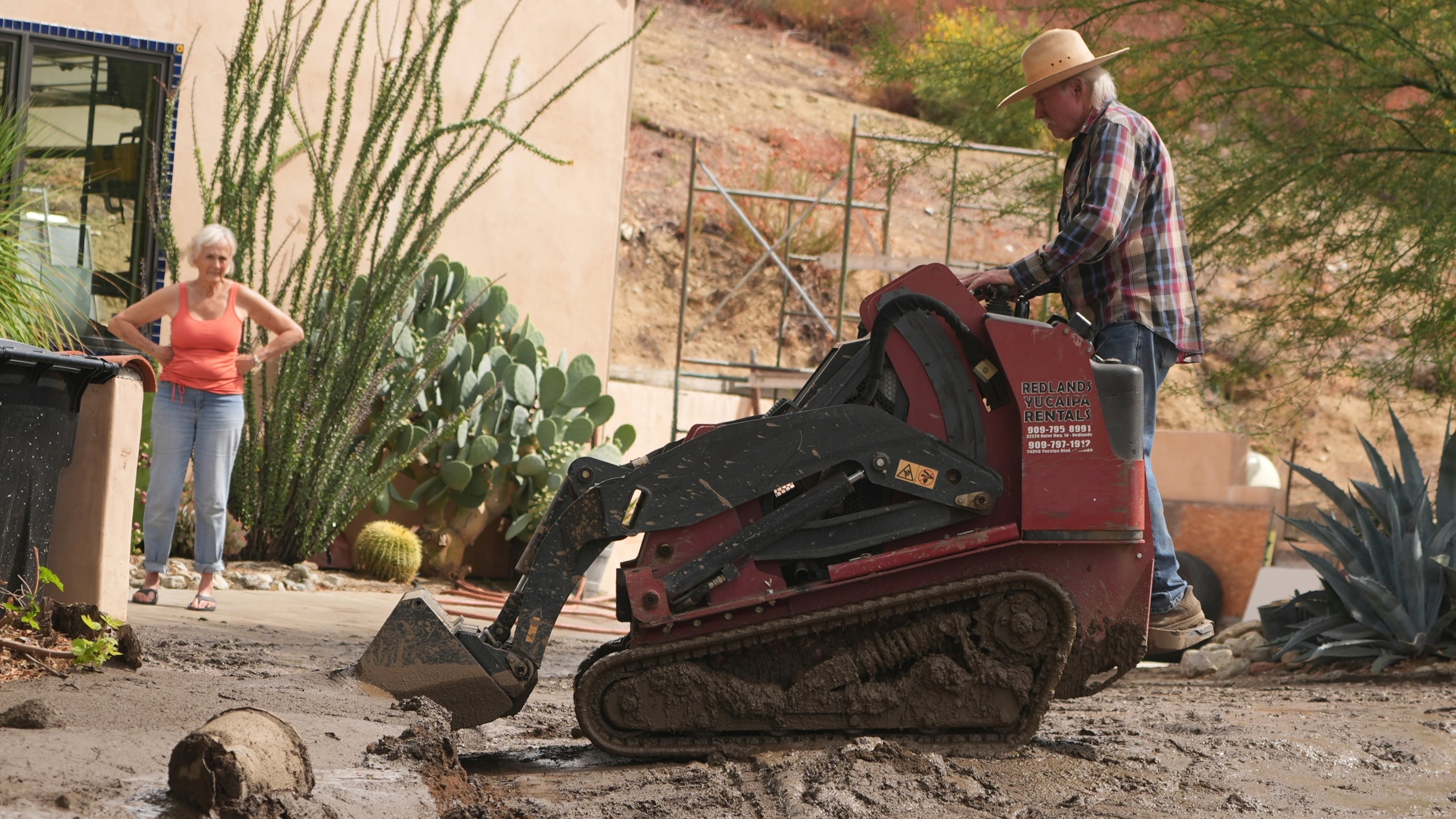 Residents clean up the damage caused by mudslides after storms in Yucaipa, Calif., Friday, Sept. 19, 2025. (AP Photo/Damian Dovarganes)