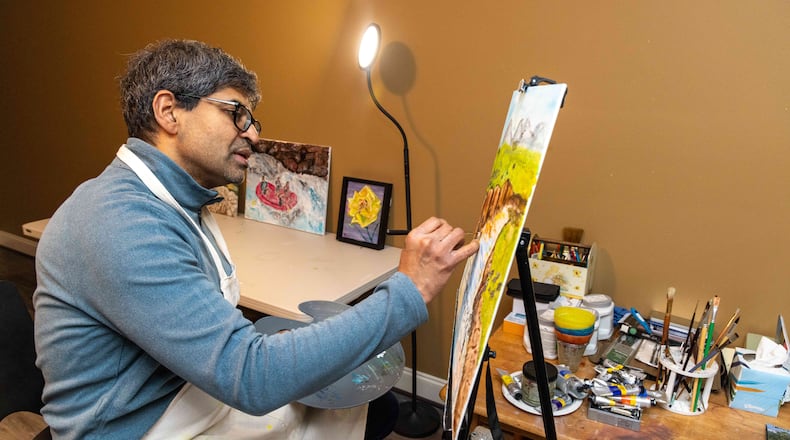 Wellstar cancer surgeon, Dr. Sahir Shroff, works on a painting in his studio at his Marietta home. He never thought his journey to medicine would lead him to find a passion for art-- referring to this moment as a "serendipitous encounter with painting." PHIL SKINNER FOR THE ATLANTA JOURNAL-CONSTITUTION