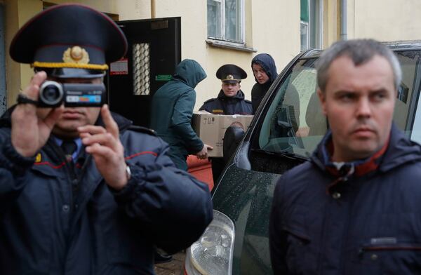 FILE - Belarusian Interior Ministry officer films journalists near the Belsat Channel during a search of the broadcaster’s office in Minsk, Belarus, on March 31, 2017. (AP Photo, File)