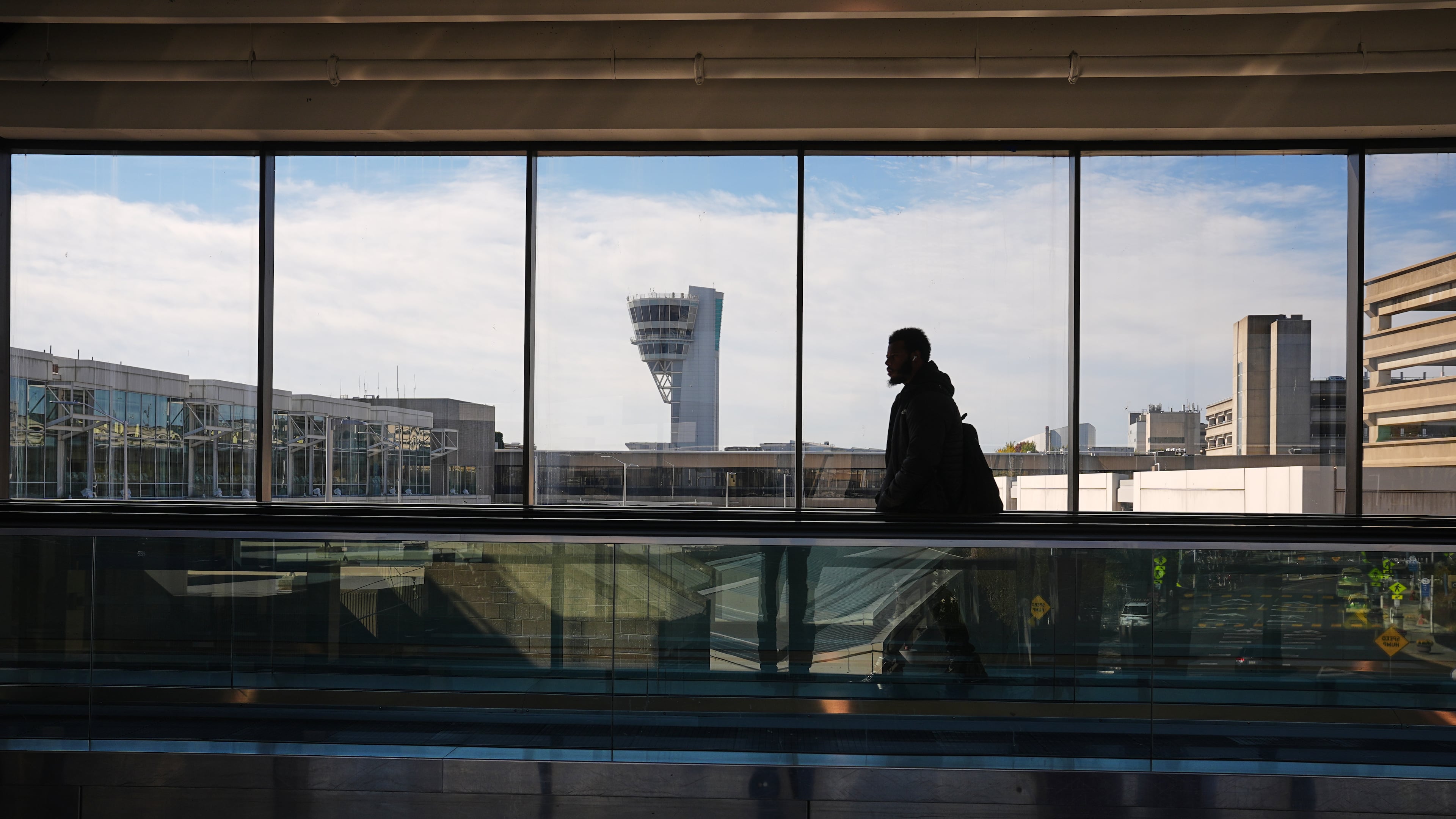 A traveler moves in view of a control tower at Philadelphia International Airport in Philadelphia, Wednesday, Nov. 5, 2025. (AP Photo/Matt Rourke)