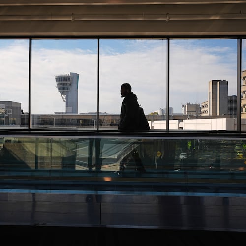 A traveler moves in view of a control tower at Philadelphia International Airport in Philadelphia, Wednesday, Nov. 5, 2025. (AP Photo/Matt Rourke)
