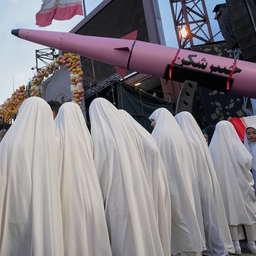 A group of girls stand beside a "Khaybar-buster" missile during a mass wedding ceremony for couples participating in the "Janfada" ("Sacrifice for Iran") pro-government campaign in Tehran, Iran, Monday, May 18, 2026. (AP Photo/Vahid Salemi)