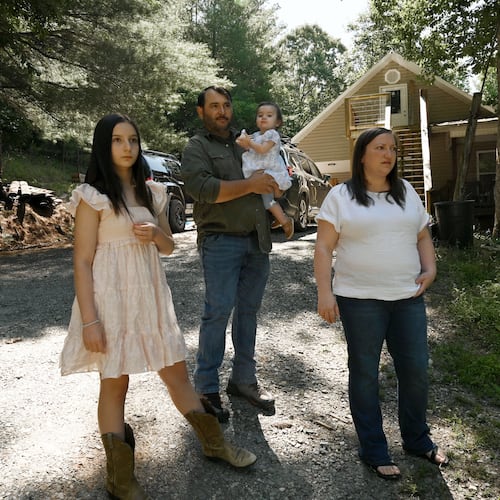 Kristy Guarnieri (right) and husband Courtney Guarnieri stand with their daughters, Stella, 12 (left) and Eliza, 1, on their property in Morganton in North Georgia on Thursday, June 4, 2026. They say their lives have been upturned by animals getting loose from the nearby Hooves and Feathers Petting Farm. (Hyosub Shin/AJC)