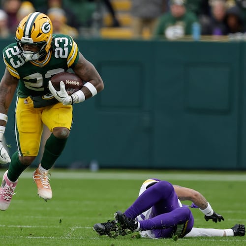 Green Bay Packers running back Emanuel Wilson (23) runs with the football after avoiding a tackle by Minnesota Vikings cornerback Byron Murphy (7), right, during the second half of an NFL football game Sunday, Nov. 23, 2025, in Green Bay, Wis. (AP Photo/Matt Ludtke)