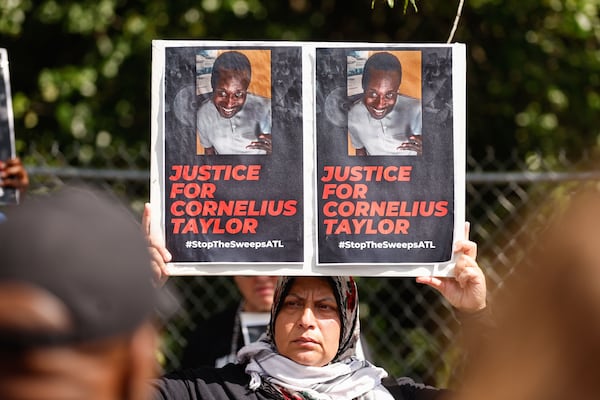 Activist Jawahir Kamil holds a sign that reads Justice for Cornelius Taylor during a press conference to protest city policies on clearing out the homeless at Old Wheat St. encampment in Atlanta on Monday, May 5, 2025. (Natrice Miller/ AJC)