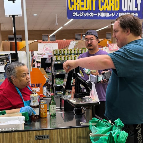 An employee checks a customer's identification card before checking out alcohol at a cash register in a grocery store in Arlington Heights, Ill., Monday, July 6, 2026. (AP Photo/Nam Y. Huh)