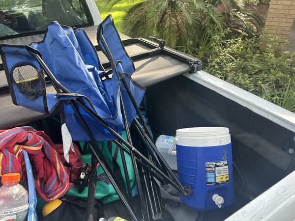 Must-have items for the back of every pickup truck: a folding chair and an ice chest. (Adam Van Brimmer/AJC)