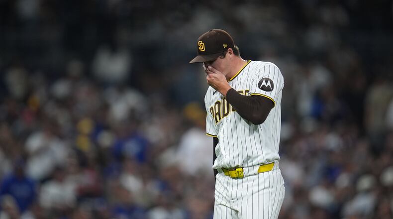 San Diego Padres pitcher Mason Miller reacts after giving up a sacrifice fly during the ninth inning of a baseball game against the Los Angeles Dodgers Tuesday, May 19, 2026, in San Diego. (AP Photo/Gregory Bull)