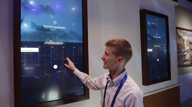 Miles Clark of Carnival Corp. demonstrates the Ocean Compass interface before CES International, Tuesday, Jan. 3, 2017, in Las Vegas. The linchpin of the concierge technology is a medallion the size of a quarter that passengers carry with them. The medallion uses wireless technologies to communicate with sensors placed around the ship and allows them to interact with displays around the ship or with crew members. (AP Photo/John Locher)