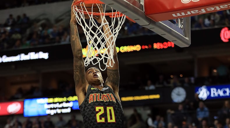 Hawks' John Collins makes a slam dunk against the Dallas Mavericks during the season opener Oct. 18, 2017, at the American Airlines Center in Dallas.