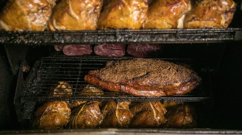 August 24, 2018- Peachtree Corners, Ga: Chicken (top) and beef brisket are shown in the smoker in the kitchen at Cue Barbecue Friday August 24, 2018, in Peachtree Corners, Ga. Cue Barbecue prides itself on all of their homemade food, including all the meat, sauces, and even the bread. This is for a feature on Cue Barbecue to be published in the October issue of Living Northside. PHOTO / JASON GETZ