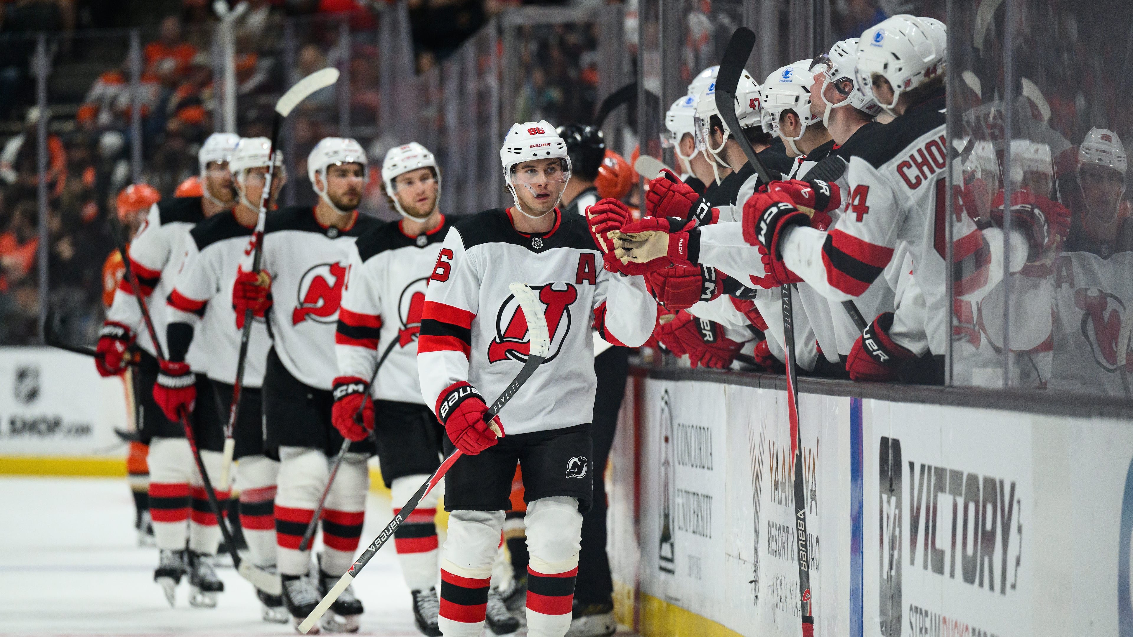 New Jersey Devils center Jack Hughes, center, greets teammates after scoring during the third period of an NHL hockey game against the Anaheim Ducks Sunday, Nov. 2, 2025, in Anaheim, Calif. (AP Photo/William Liang)