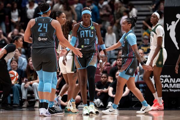 The Dream's Rhyne Howard (centers) celebrates with teammates after scoring against the Storm during a WNBA basketball game in Vancouver, British Columbia, on Friday, Aug. 15, 2025. (Ethan Cairns/The Canadian Press via AP)
