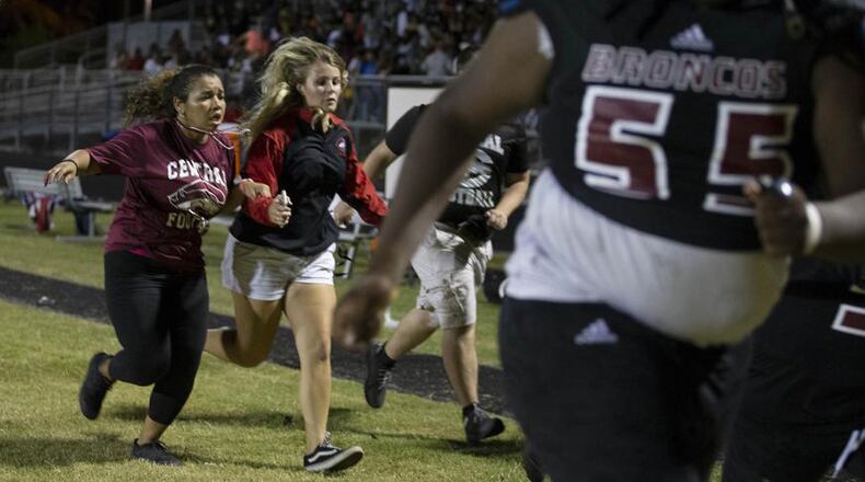 Running for cover at the sounds of shots fired at Palm Beach Central in Wellington, Florida on August 17, 2018. (Allen Eyestone / The Palm Beach Post)