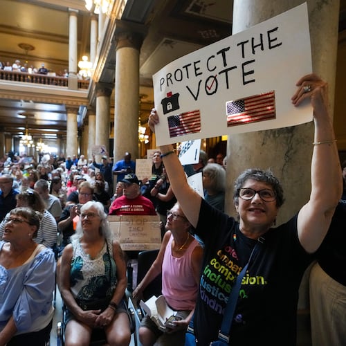 FILE - Annette Groos holds a sign before the start of a rally featuring former Transportation Secretary Pete Buttigieg at the Statehouse in Indianapolis, Thursday, Sept. 18, 2025 for Indiana Democrats amid pressure from President Donald Trump on Republicans who control the state's legislature to redistrict congressional seats. (AP Photo/Michael Conroy, File)