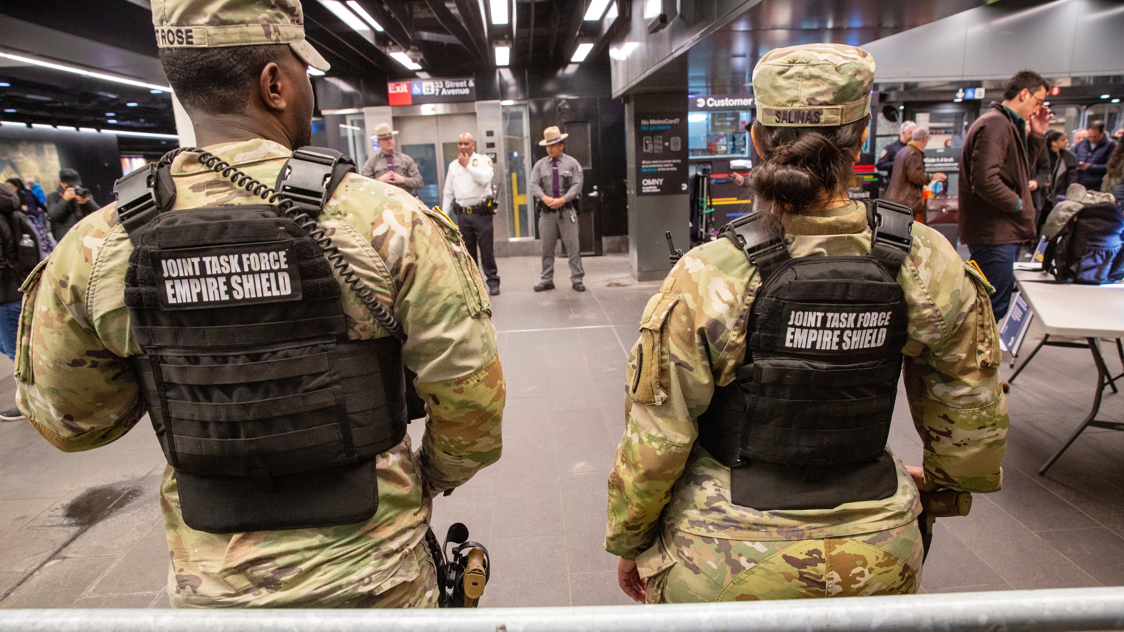 FILE - Members of the Armed Forces, including the National Guard, patrol the subway system in Penn Station as police officers check commuters' bags in New York on Thursday, March 7, 2024. (AP Photo/Ted Shaffrey, File)