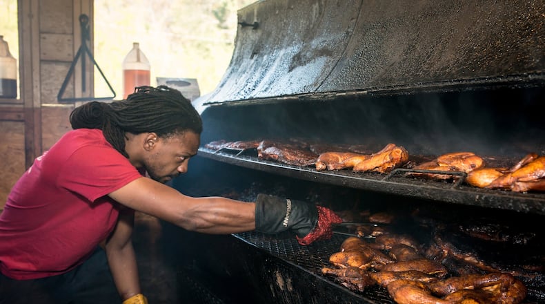 Chef Bryan Furman, shown arranging meat on the smoker at B’s Cracklin Barbecue in Atlanta, plans to rebuild after a recent fire at his restaurant.