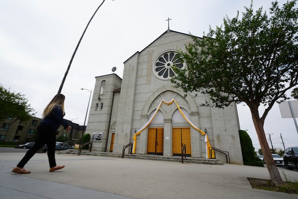 Melyssa Rivas walks outside a location where she witnessed masked federal agents detaining a person earlier this month outside Our Lady of Perpetual Help Catholic Church in Downey, Calif., on Friday, June 20, 2025. (AP Photo/Damian Dovarganes)